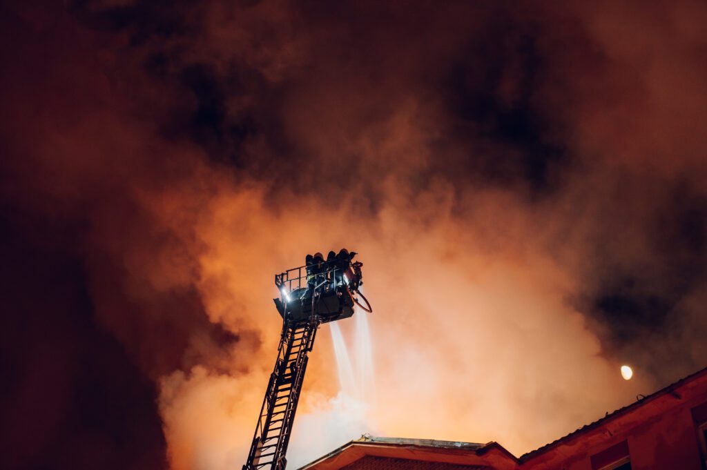 Firefighters dousing a home with water